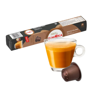 Outin капсула за кафе и чаша с пенлива напитка, разположени на фона на кутия Gimoka Pistacchino.