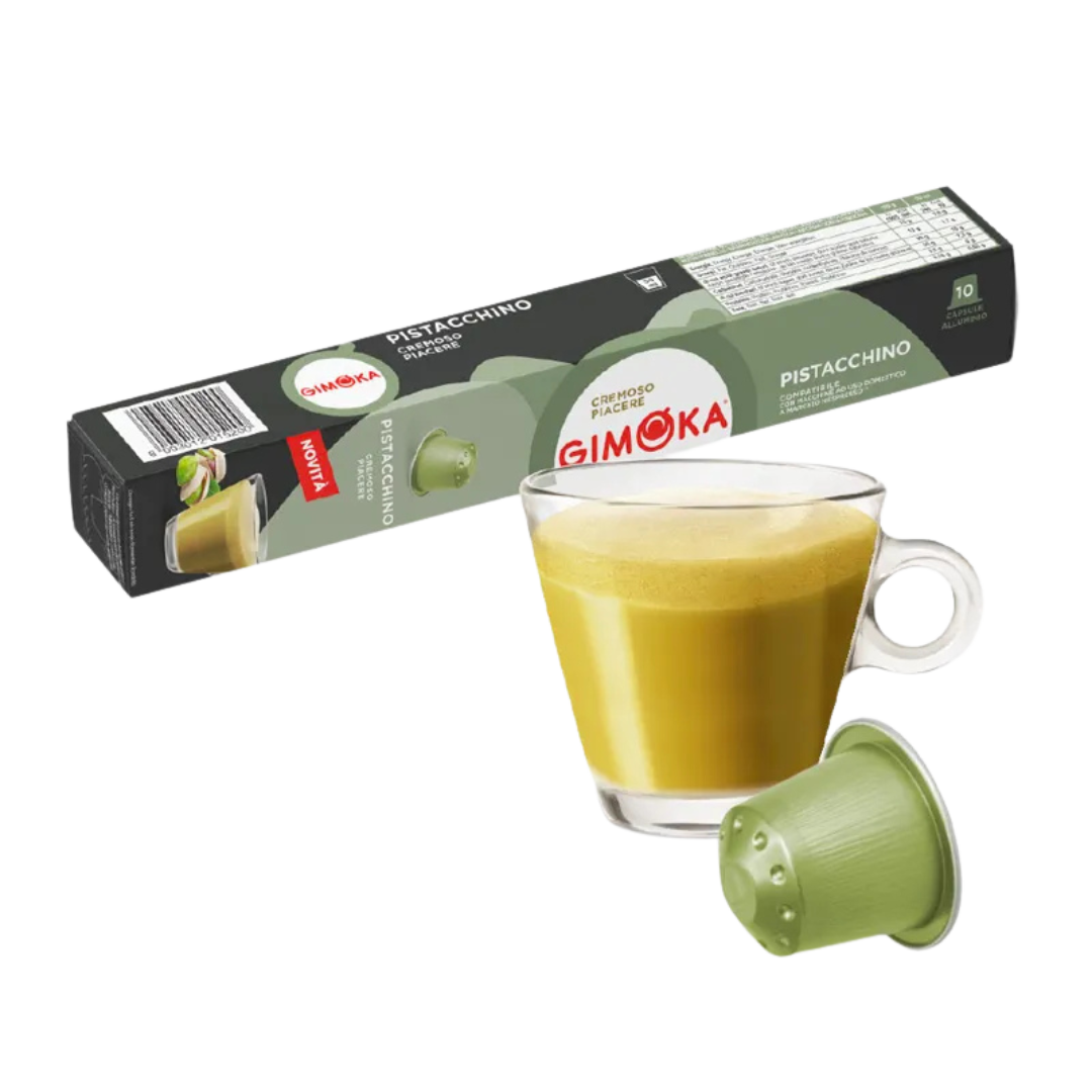 Кутия с шушулки GIMOKA PISTACCHINO до чаша зелено кафе с каймак и шушулка Outin на преден план.