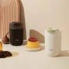 Две чаши Outin Travel Tumblers, черни и бели, са разположени до фланела, кафе на зърна и смокиня върху бежова повърхност. Две чаши Outin Travel Tumblers, черни и бели, са разположени до фланела, кафе на зърна и смокиня върху бежова повърхност.